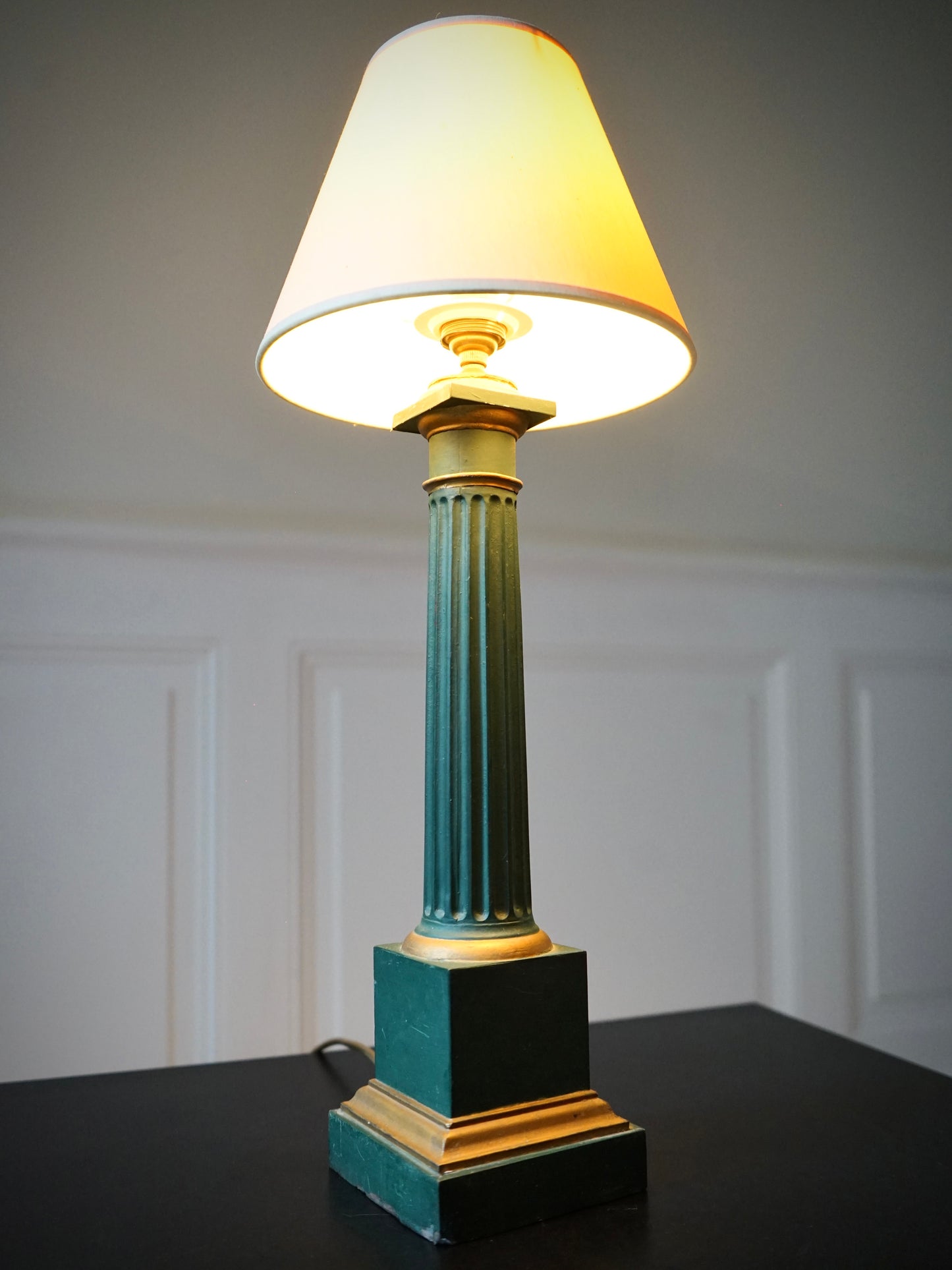Lampe à poser en forme de colonne cannelée en métal vert et doré.